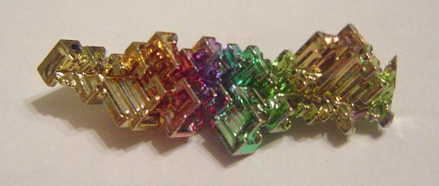 "Bismuth Crystal". Licensed under Public domain via Wikimedia Commons - https://commons.wikimedia.org/wiki/File:Bismuth_Crystal.jpg#mediaviewer/File:Bismuth_Crystal.jpg