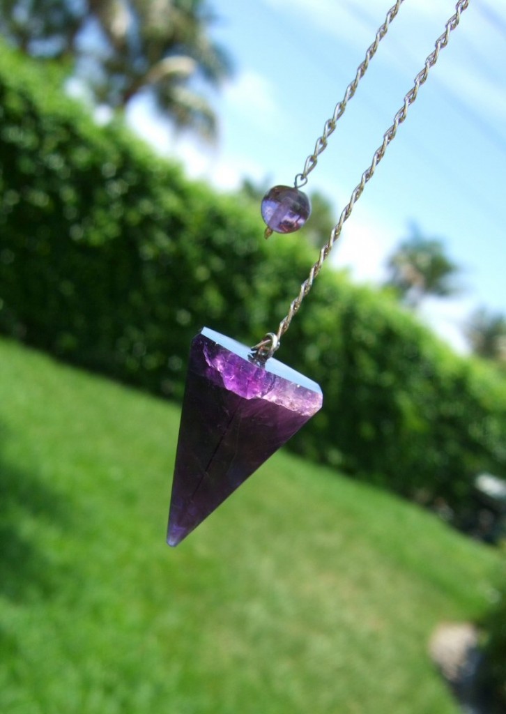 Holding my Black Amethyst pendulum out in the sun so I can see all its inner attributes really well. 